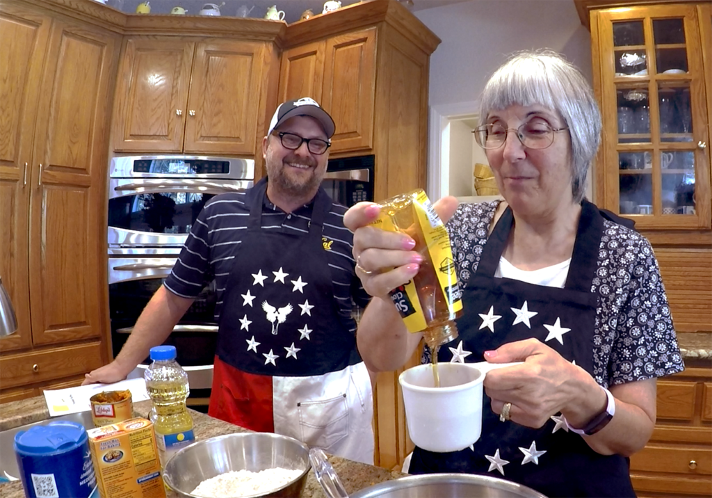 Photo of two people in a kitchen baking.