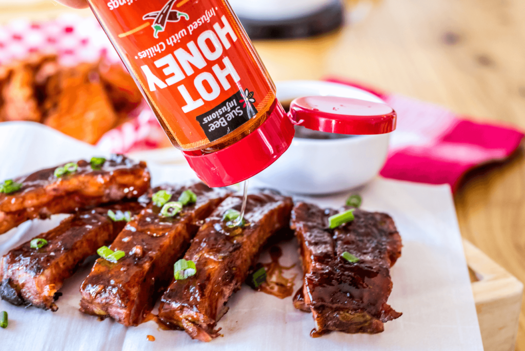 Photo of SUE BEE® INFUSIONS™ Hot Honey and BBQ ribs.